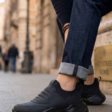 Men's black sneakers with lace-up closure, cushioned collar, and chunky rubber sole
