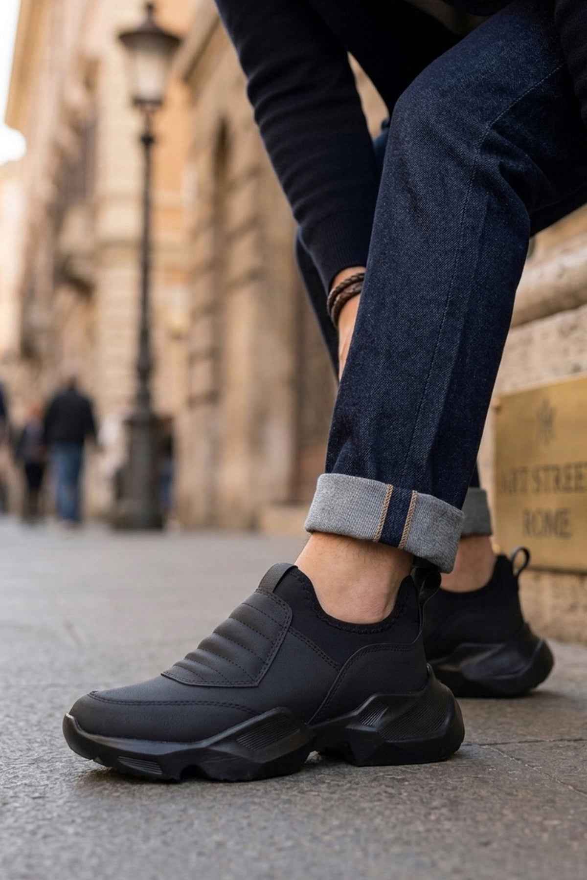 Men's black sneakers with lace-up closure, cushioned collar, and chunky rubber sole