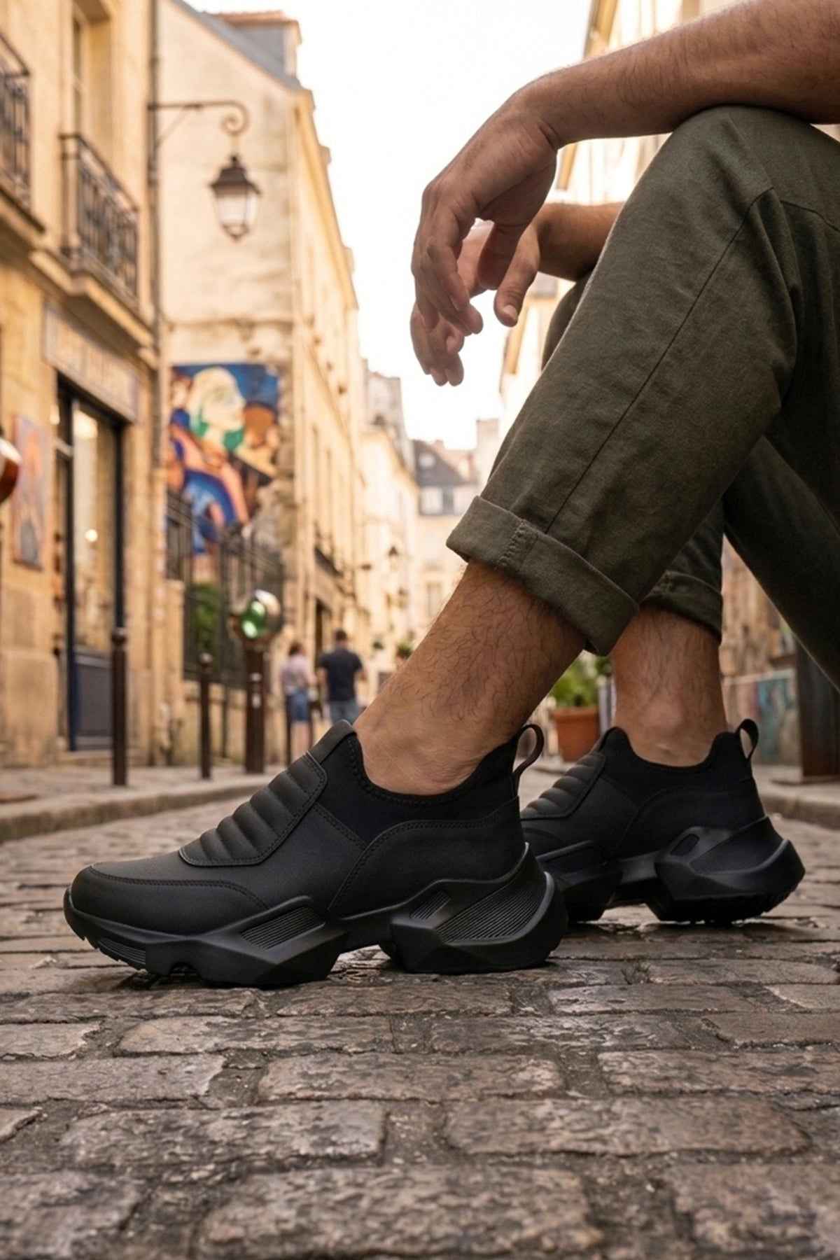 Men's black lace-up sneakers with textured side panels and thick treaded rubber sole