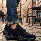 Black low-top lace-up sneakers with sock-like cuff and chunky sole
