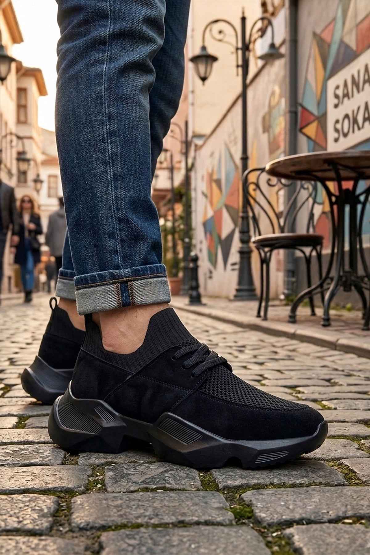 Black low-top lace-up sneakers with sock-like cuff and chunky sole