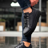 Men's black sneakers with thick ridged outsole and lace-up closure, close-up