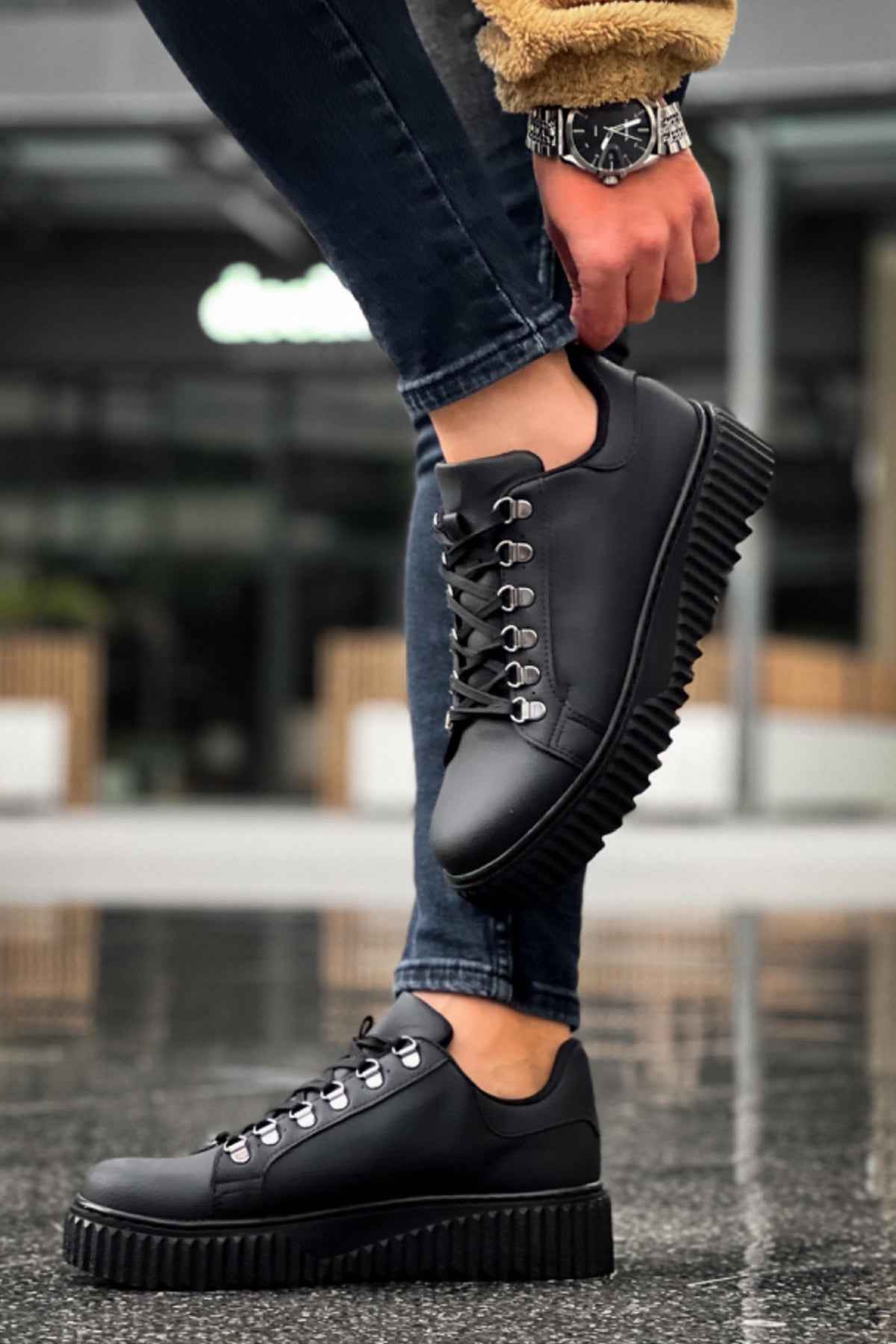 Men's black sneakers with thick ridged outsole and lace-up closure, close-up
