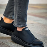 Men's black slip-on sneakers with smooth upper and stitched side, flat rubber sole