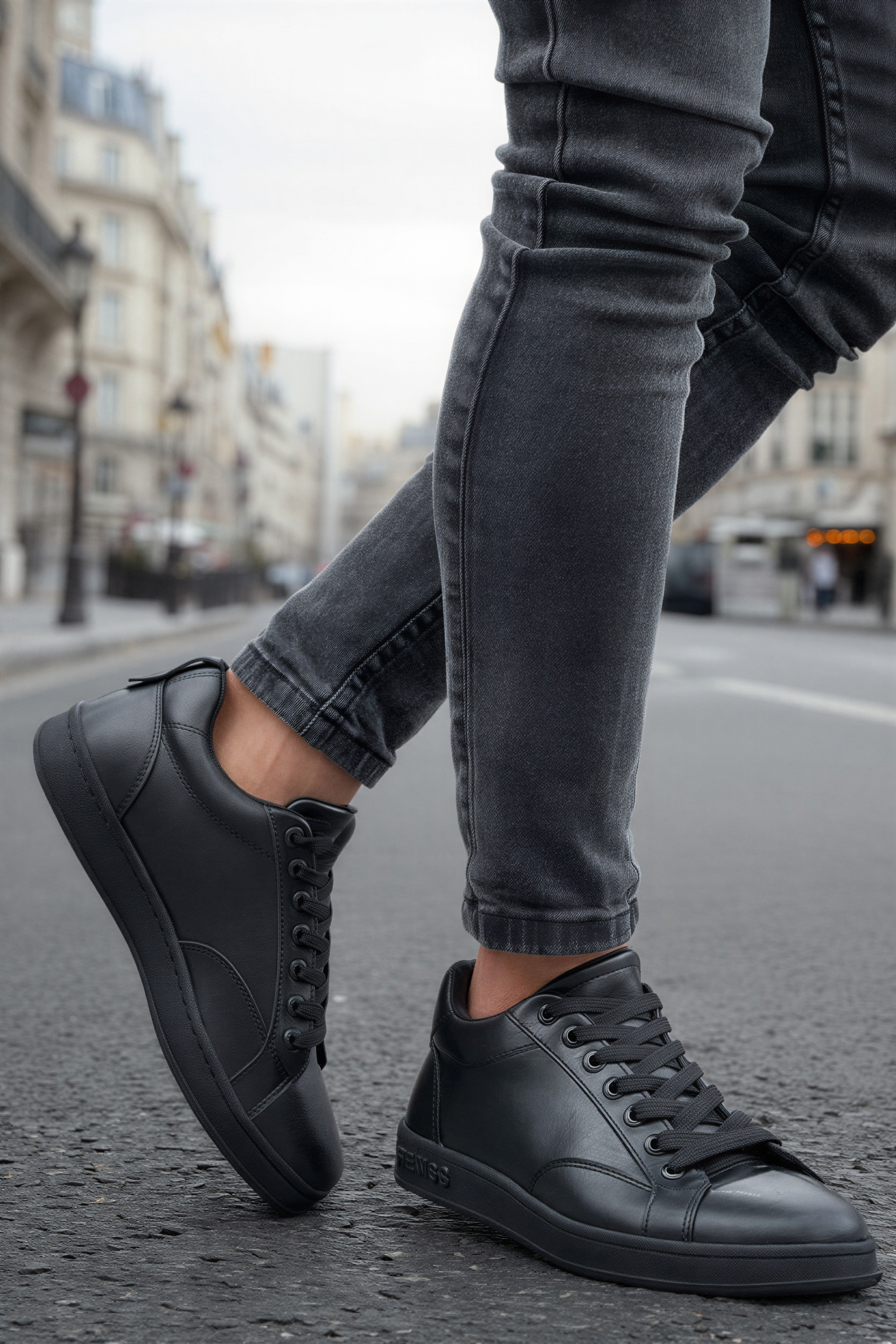 Black lace-up sneakers with smooth toe cap and side stripe paneling.