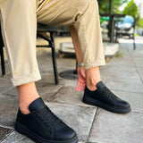 Black low-top sneakers, lace-up with textured upper and rubber sole