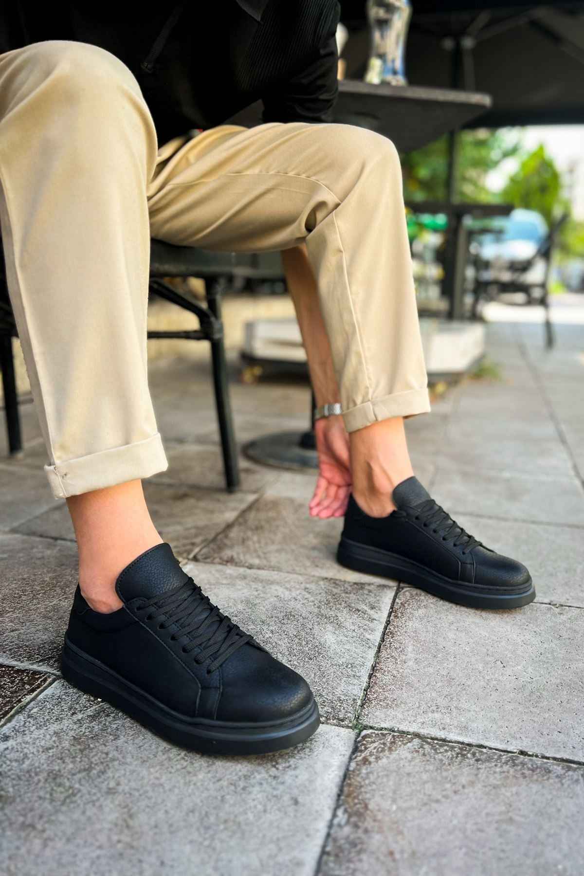 Black low-top sneakers, lace-up with textured upper and rubber sole