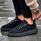 Black suede sneakers, side view with lace-up closure and cushioned sole