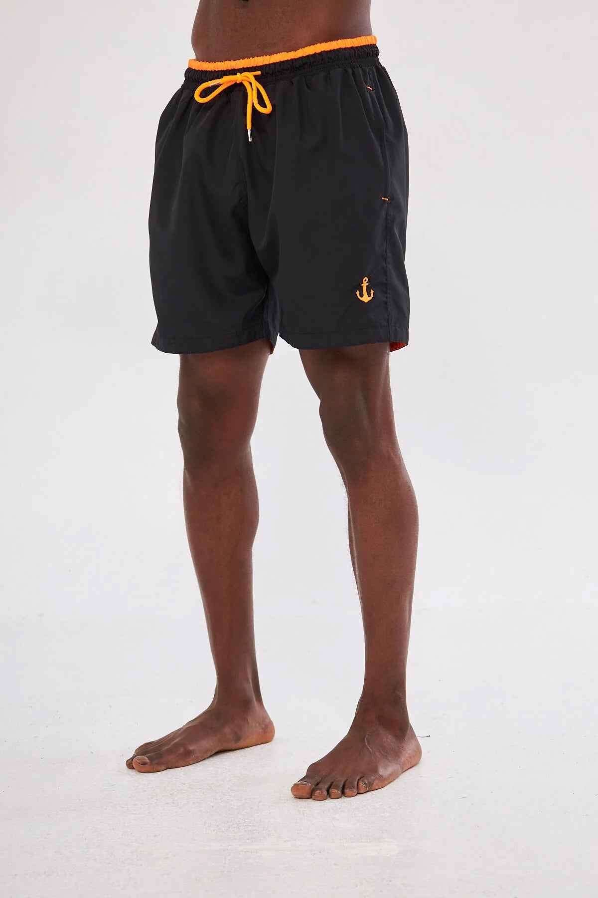 Men's black swim shorts, back view with orange waistband cord and anchor logo.
