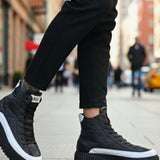 Black lace-up boots with white sole, worn with dark pants