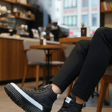 Black lace-up boots with white midsole and thick tread sole