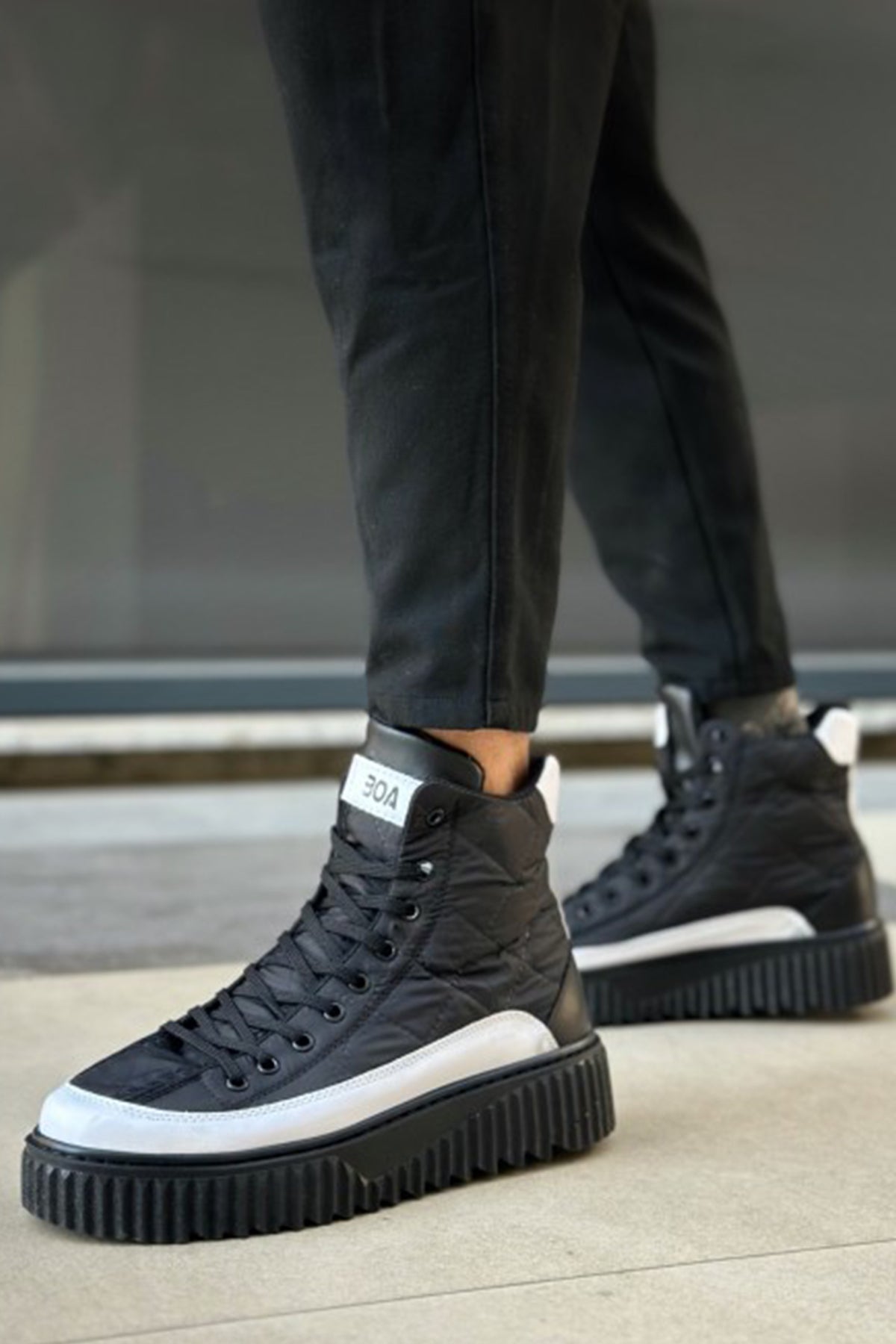 Black lace-up high-top boots with white trim and chunky platform sole