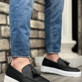 Black men's tassel loafer with slip-on design and white rubber sole