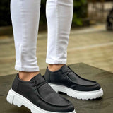 Men's black slip-on shoes with white chunky sole, textured upper and stitching