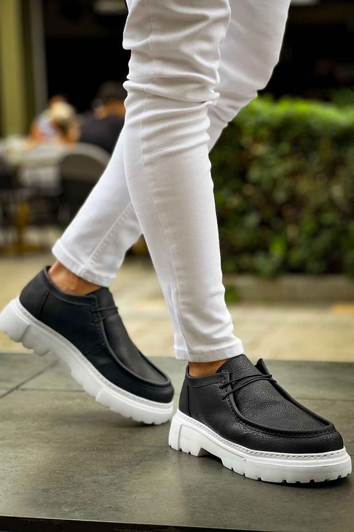 Men's black slip-on shoes with white chunky sole, front moc-toe design