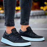 Men's black low-top sneakers with textured upper, lace-up front, white sole