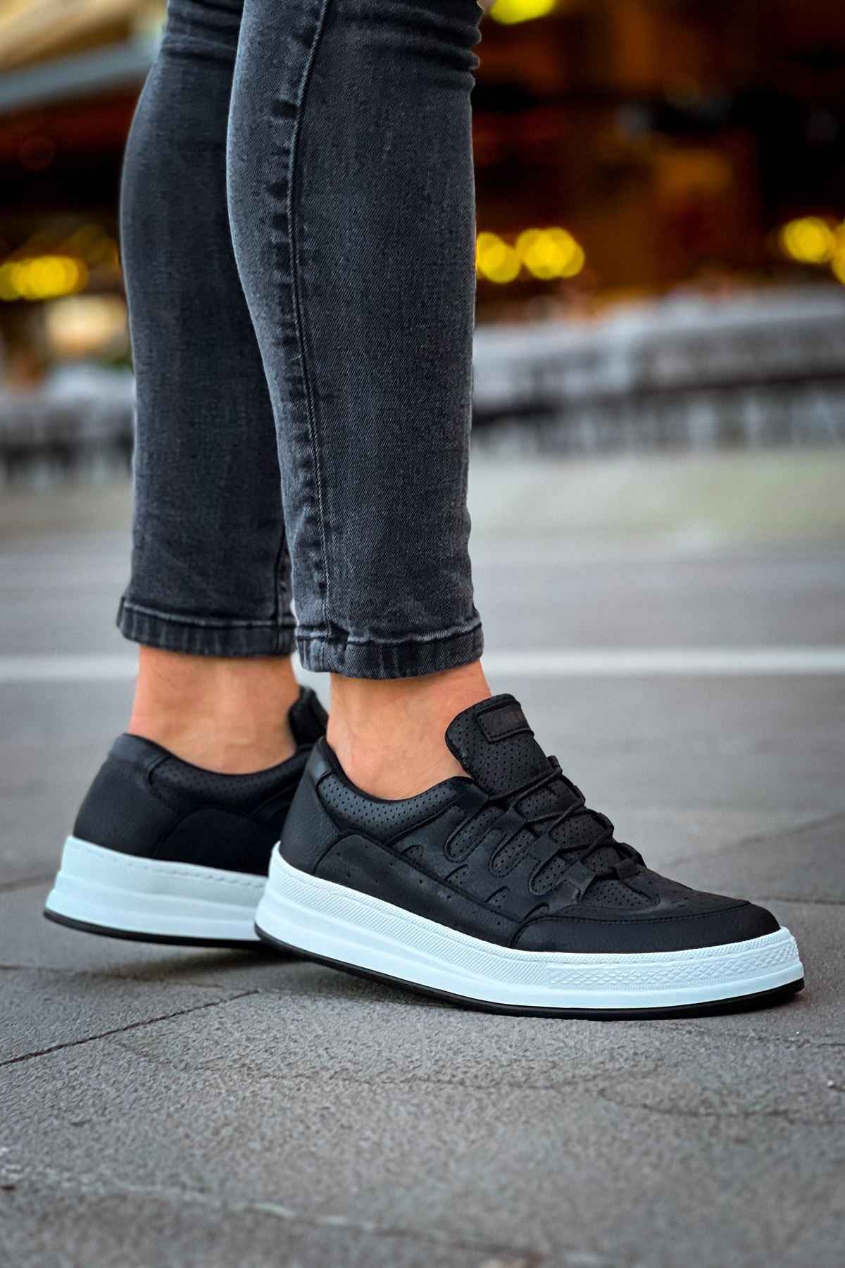 Men's black low-top sneakers with lace-up top and white sole, side view