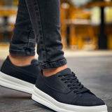 Black low-top lace-up sneakers with white rubber sole and textured upper