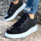 Black low-top sneakers with two straps and white rubber sole