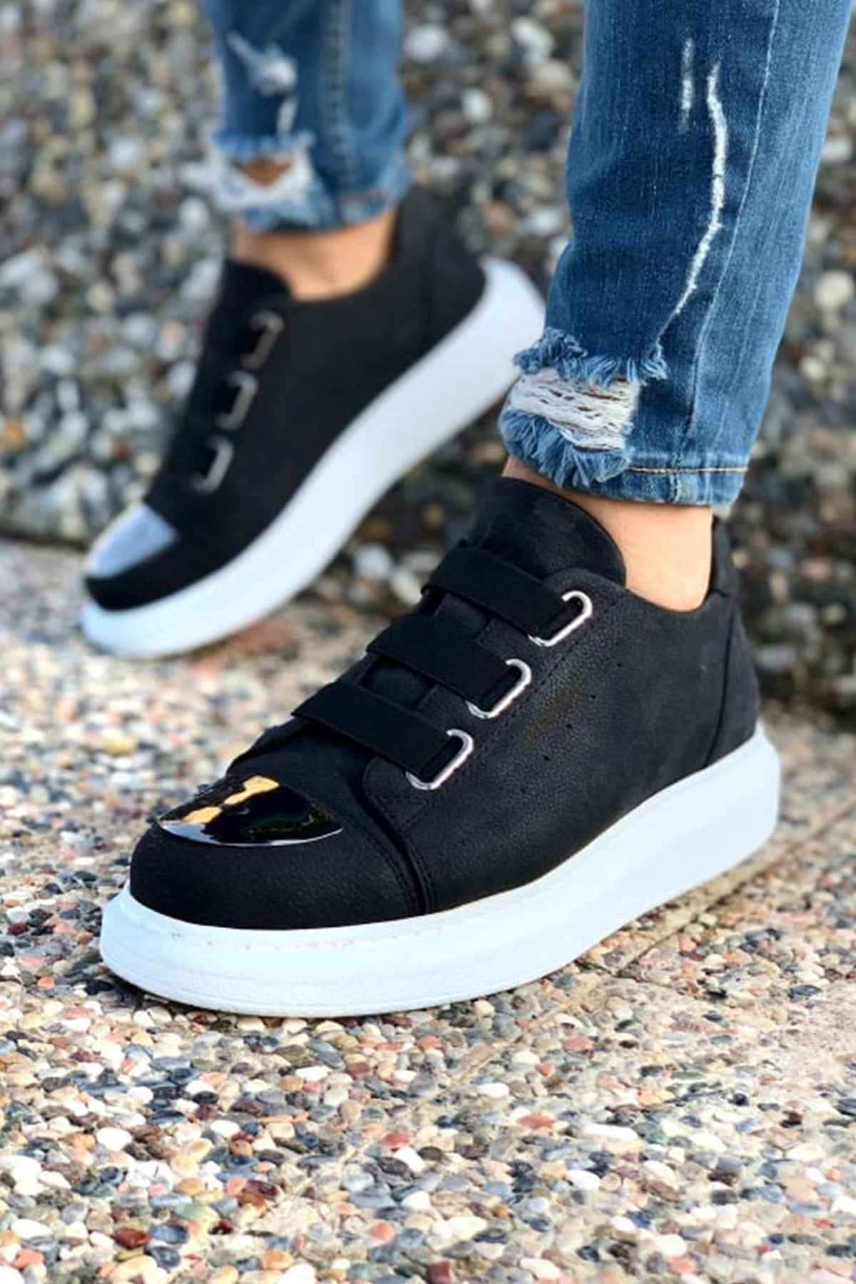 Black low-top sneakers with two straps and white rubber sole