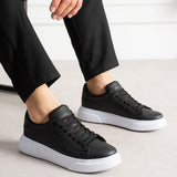 Black low-top sneakers with white rubber sole and lace-up design