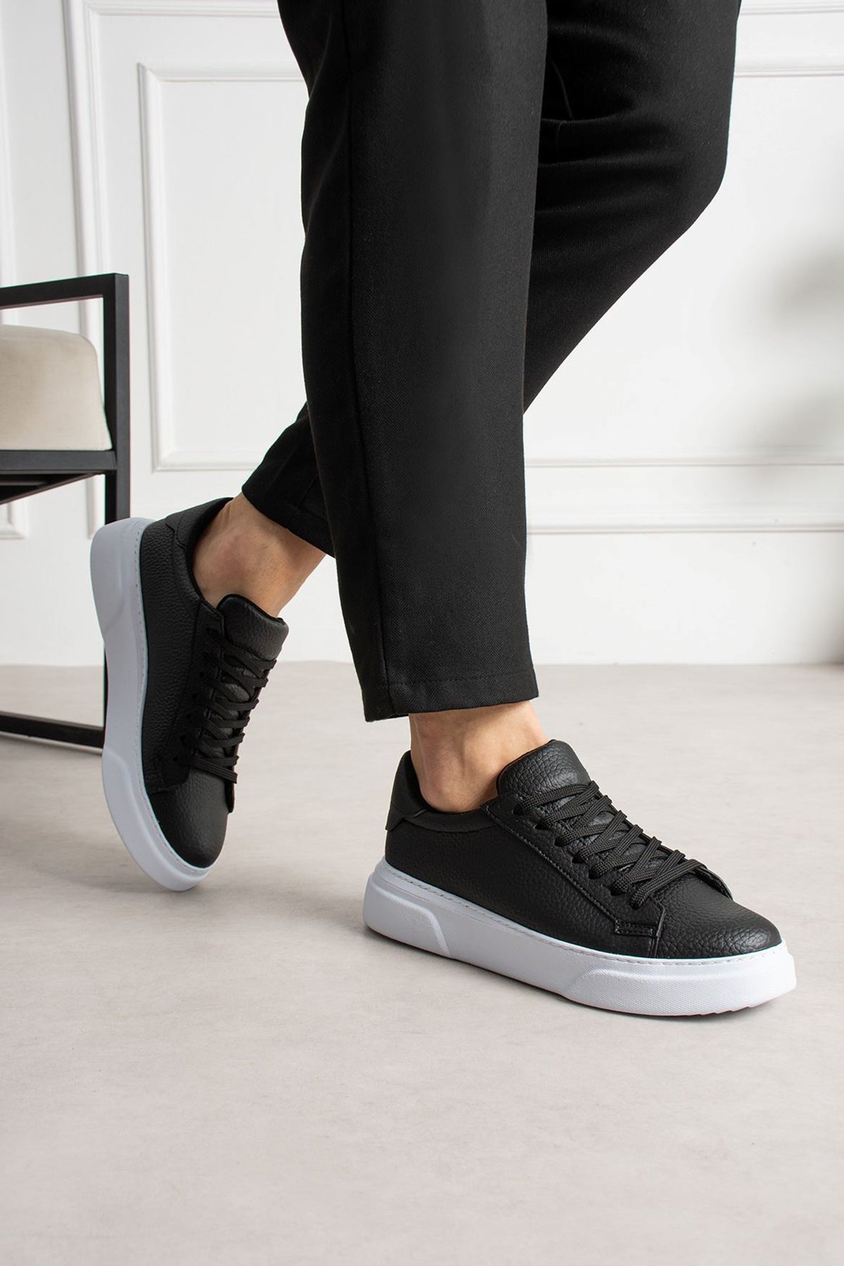 Black lace-up low-top sneakers worn with white midsole