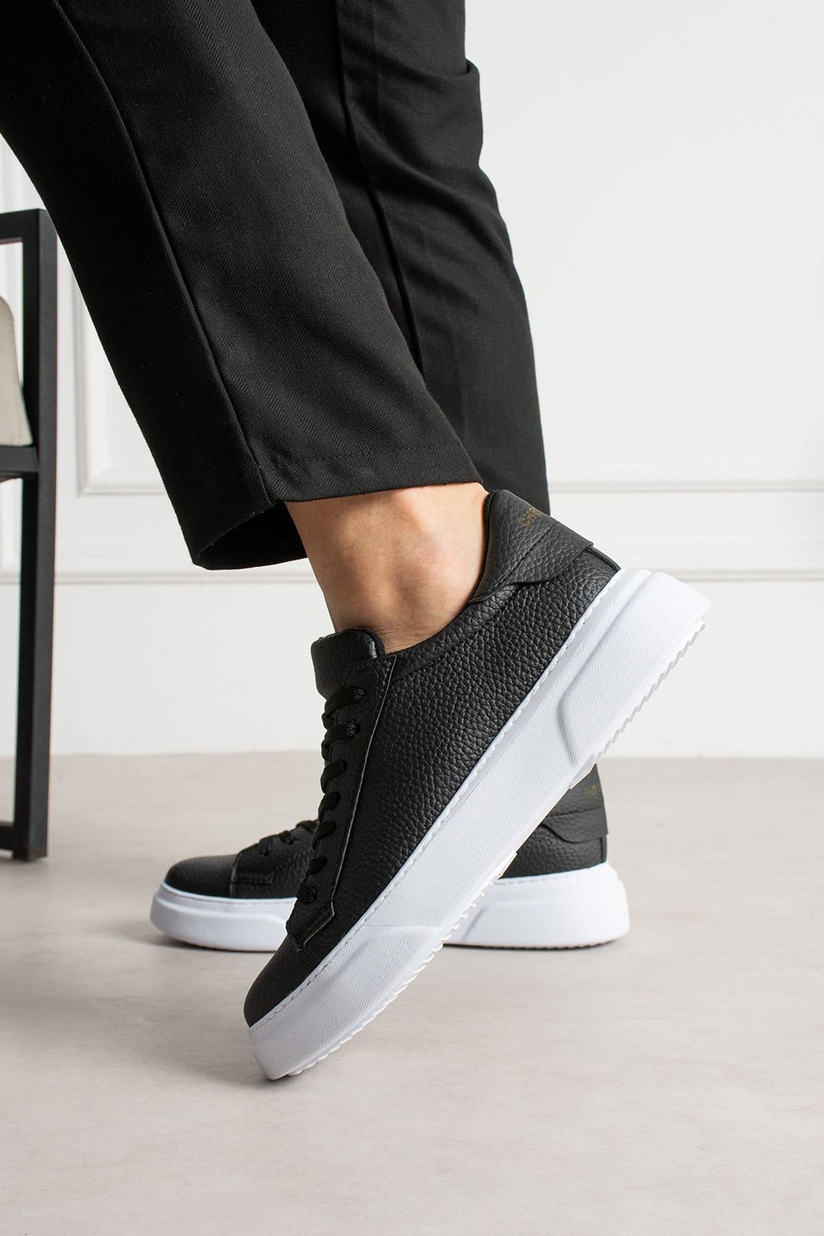Black textured lace-up sneakers with thick white sole