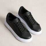 Pair of black leather-look lace-up sneakers with white platform soles