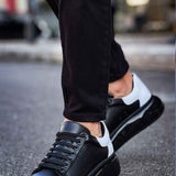 Black lace-up sneakers with white heel accent and thick black sole