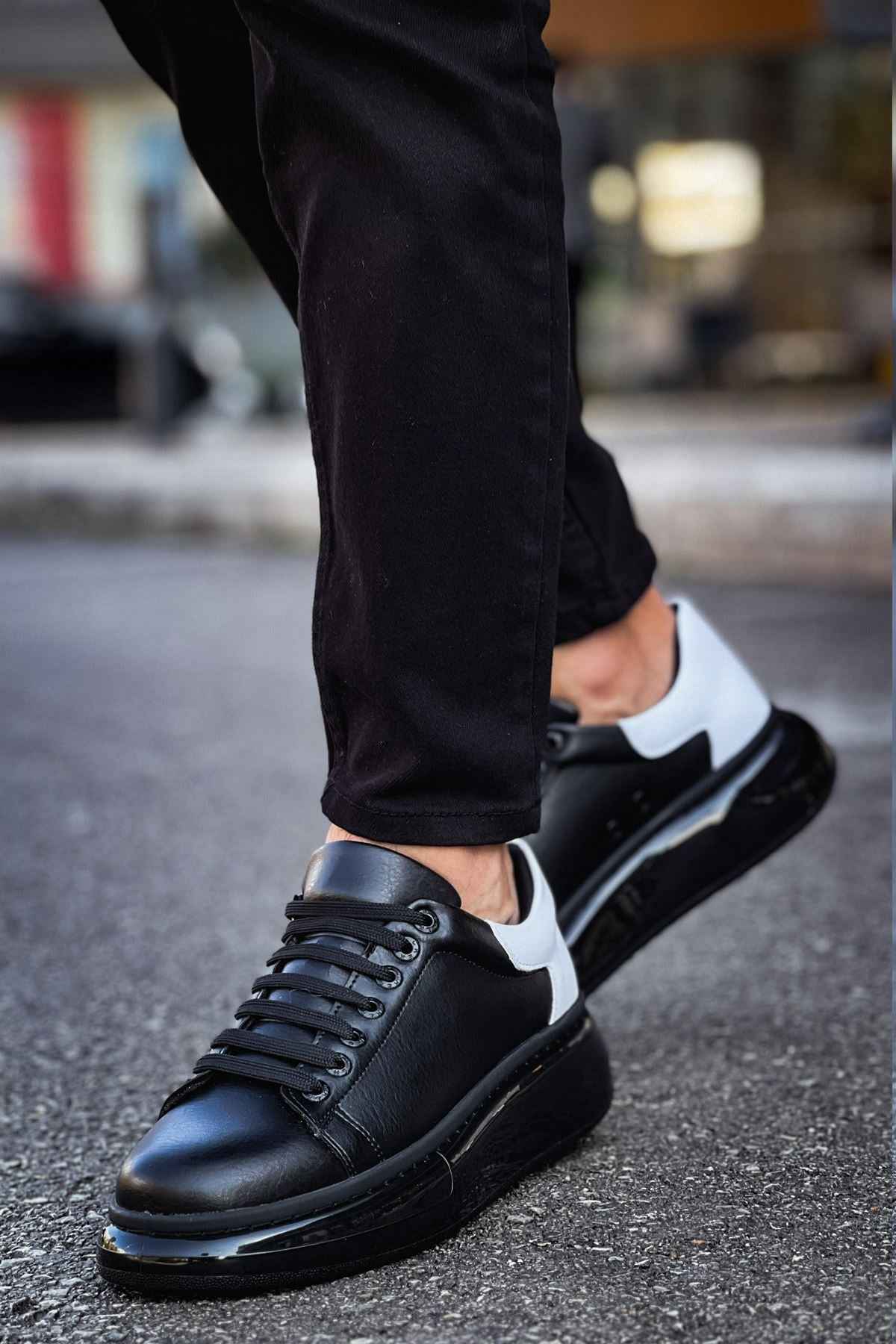 Black lace-up sneakers with white heel accent and thick black sole