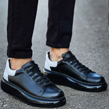 Black lace-up sneakers with white side accent, rounded toe, and thick sole