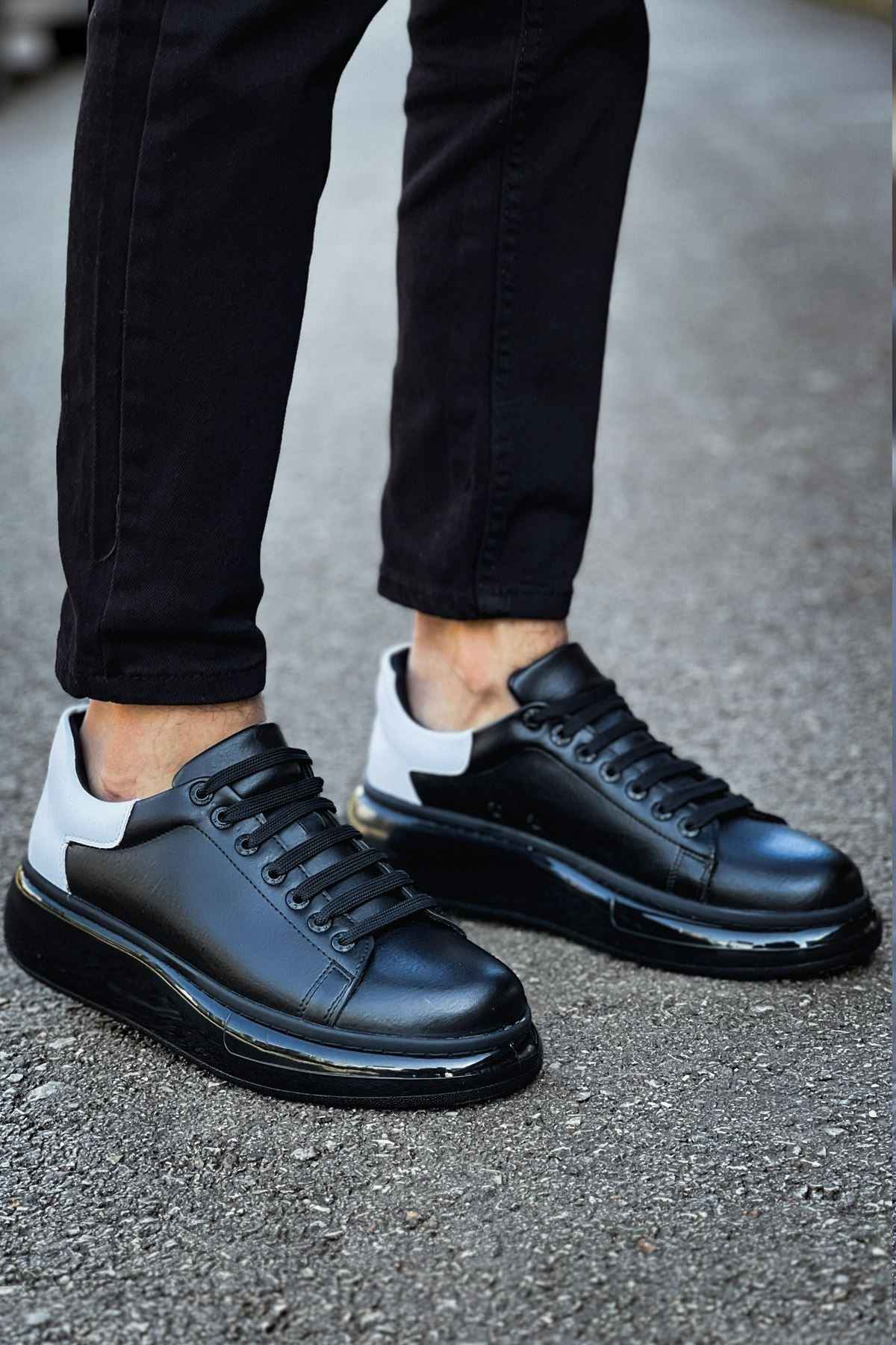 Black lace-up sneakers with white side accent, rounded toe, and thick sole