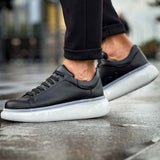 Men's black lace-up sneakers with white midsoles, side profile view