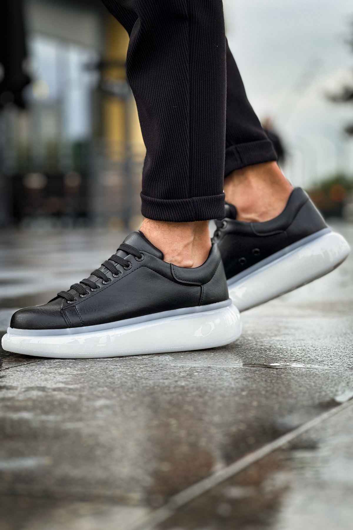 Men's black lace-up sneakers with white midsoles, side profile view