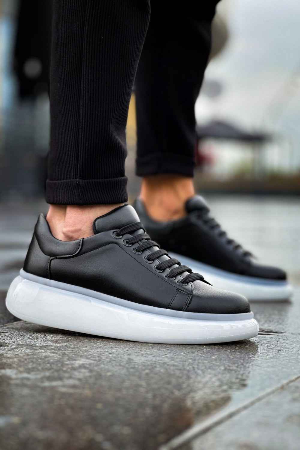 Men's black low-top sneakers with white rubber sole and stitched laces