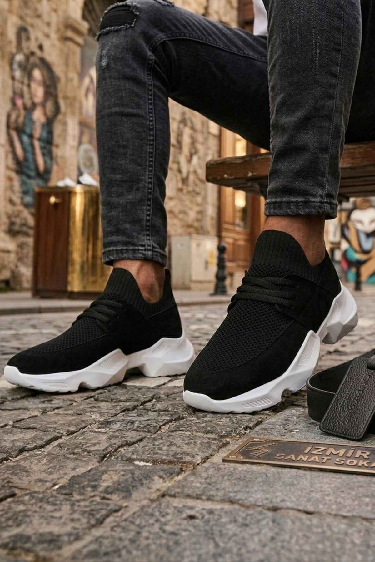 Men's black knit lace-up sneakers with white sole, angled front side view