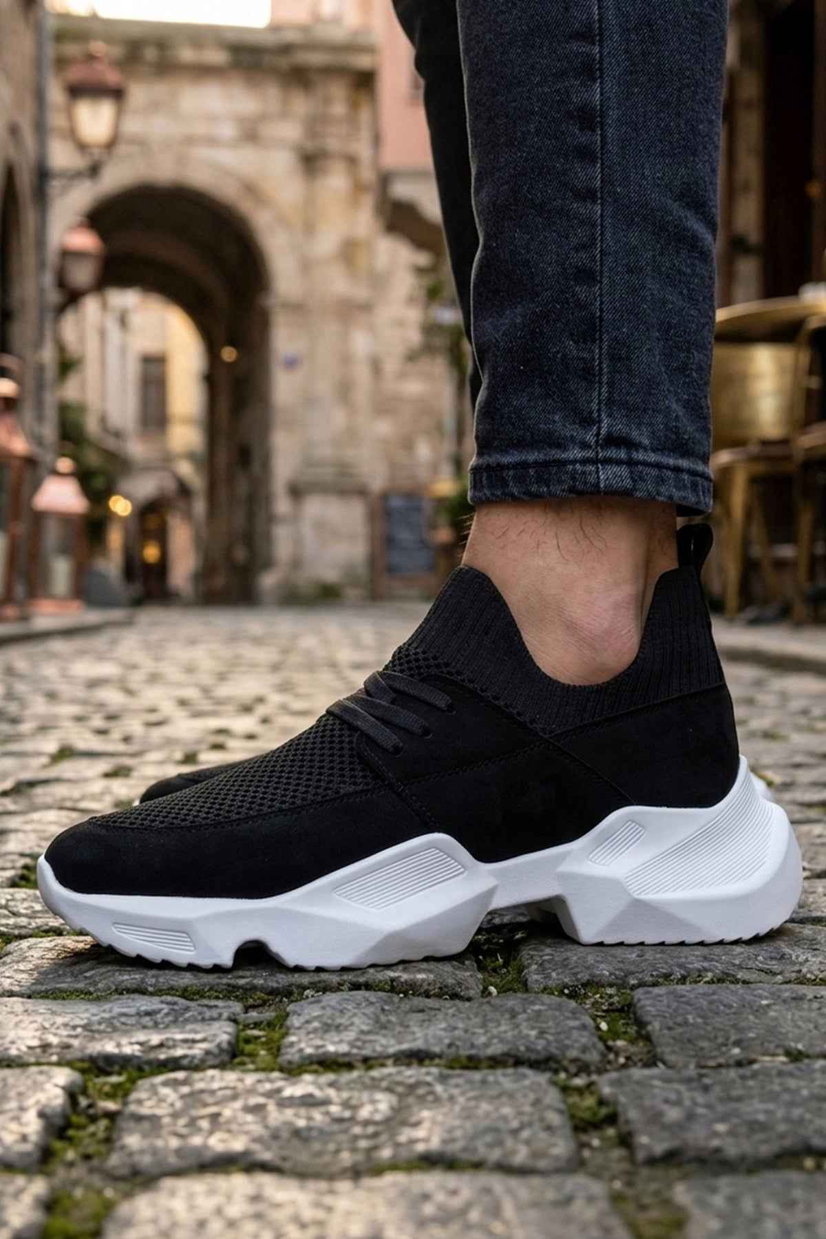 Men's black knit lace-up sneakers with white sole, front side view