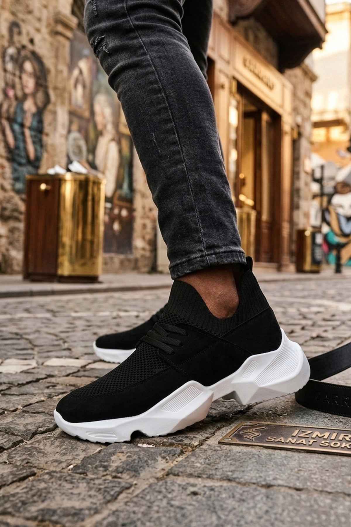 Men's black knit lace-up sneakers with white sole, angled step side view