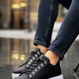 Men's black sneakers with white sole, lace-up front, and side panels