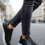 Men's black low-top lace-up sneakers with white midsole and black laces
