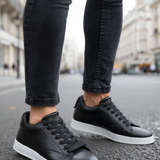 Men's black low-top lace-up sneakers with white soles and side stitching