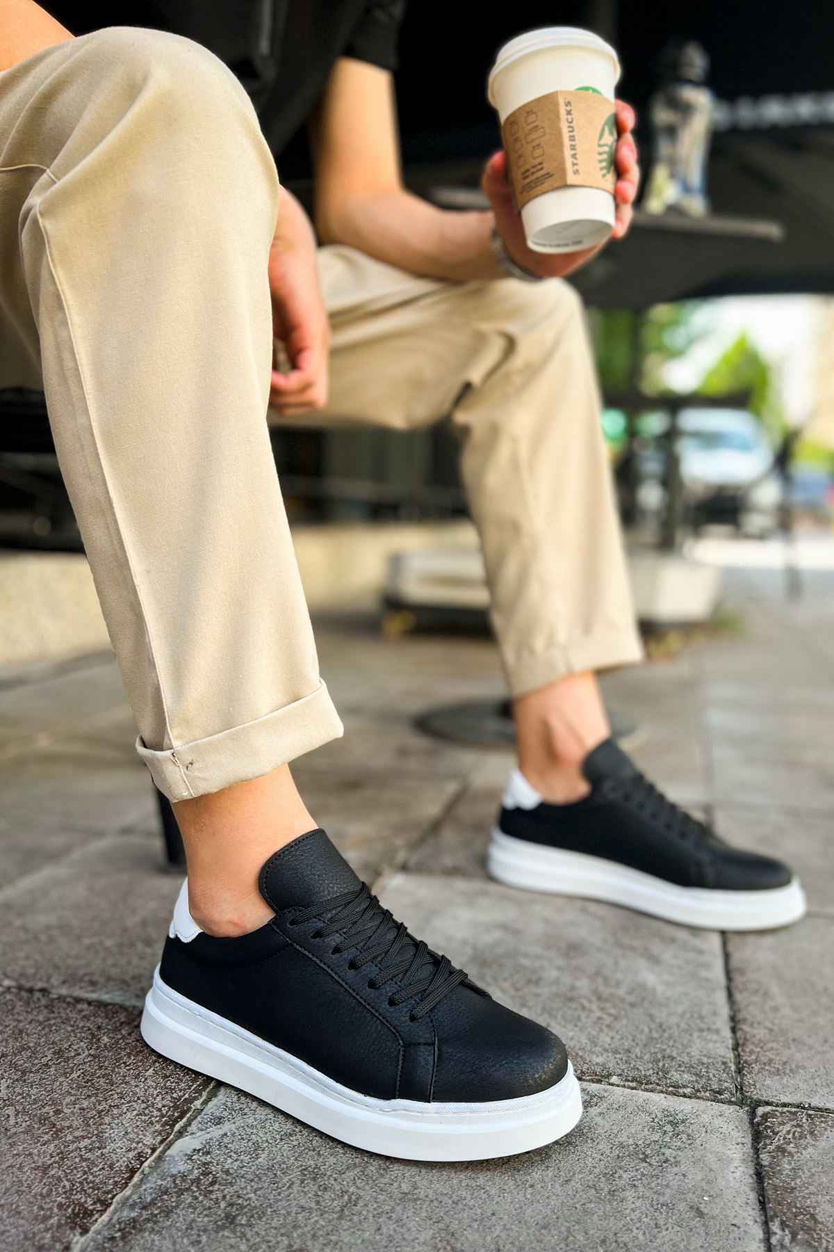 Men's black low-top sneakers with white rubber sole and lace-up design
