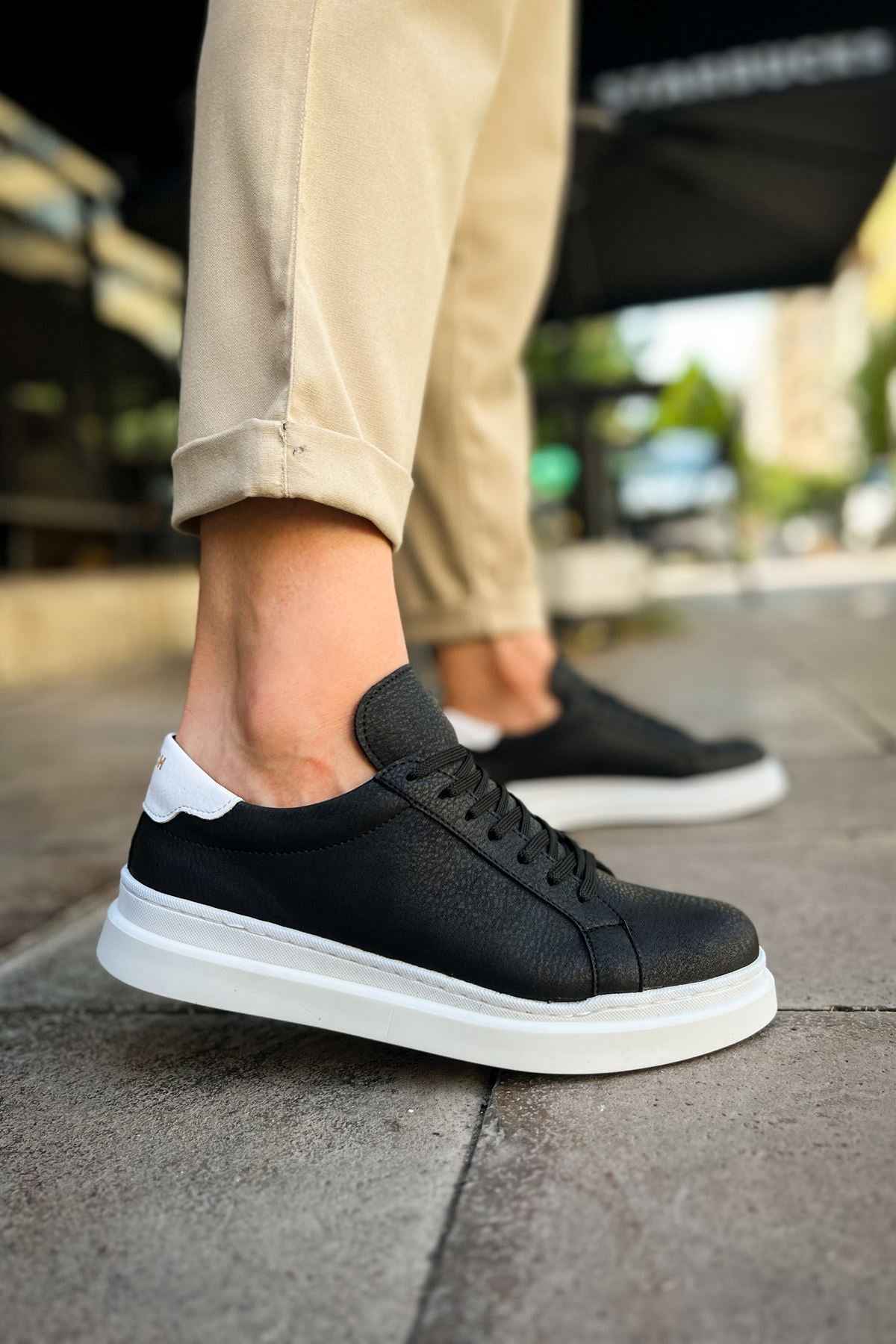 Men's black lace-up sneakers with white midsole and textured side panels