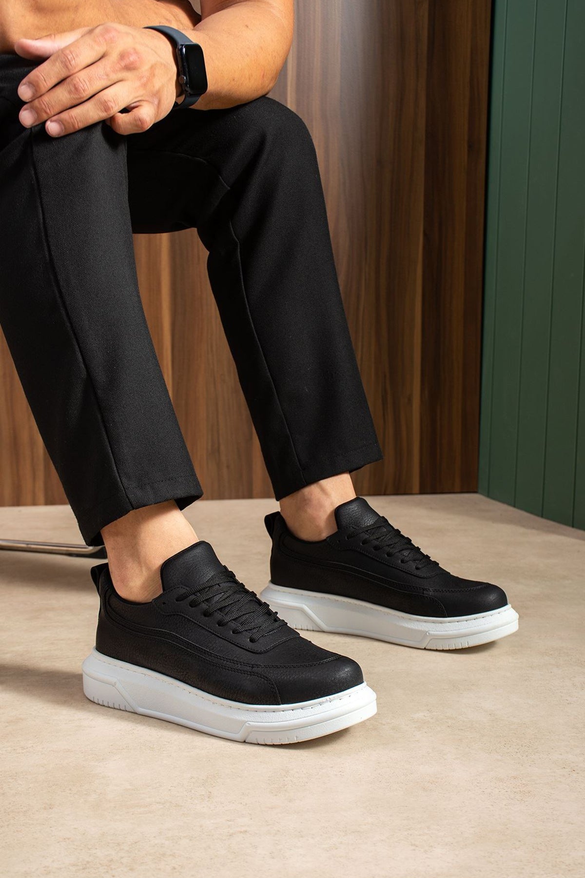 Black lace-up sneakers with white rubber sole, side view