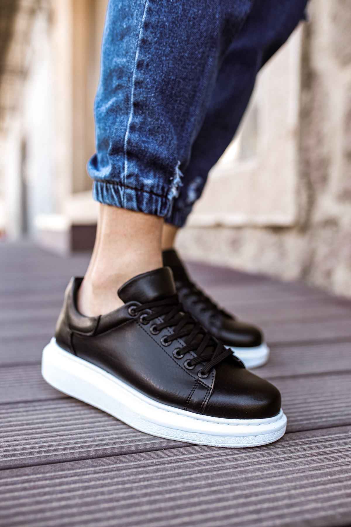 Men's black sneakers with white sole, lace-up front view