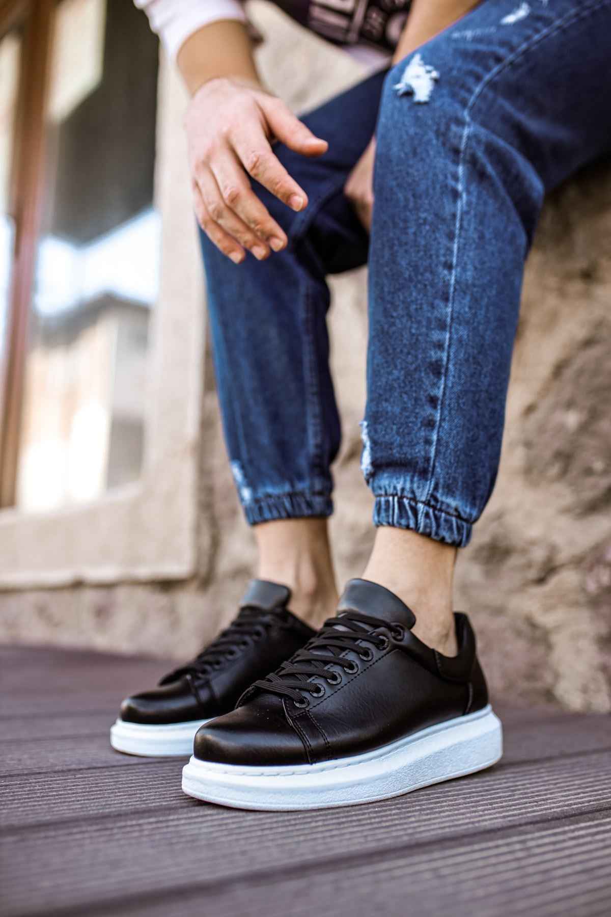 Men's black lace-up sneakers with white midsole, side view