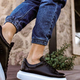 Men's black leather sneakers with white sole, angled side view