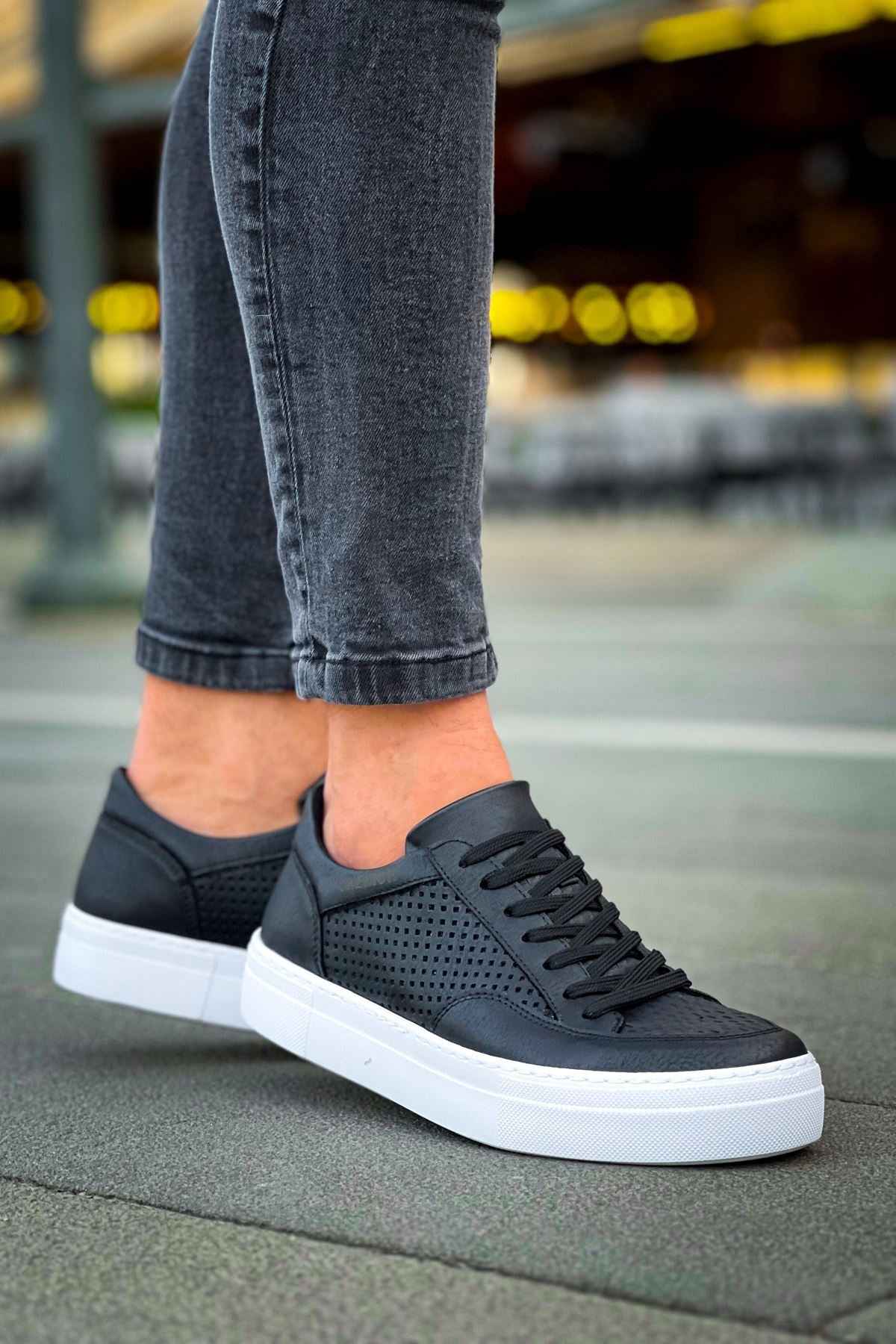 Black lace-up sneakers with perforated toe and white cupsole