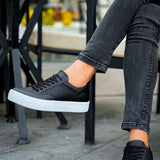 Black low-top sneakers with perforated upper, lace-up front, and white rubber sole