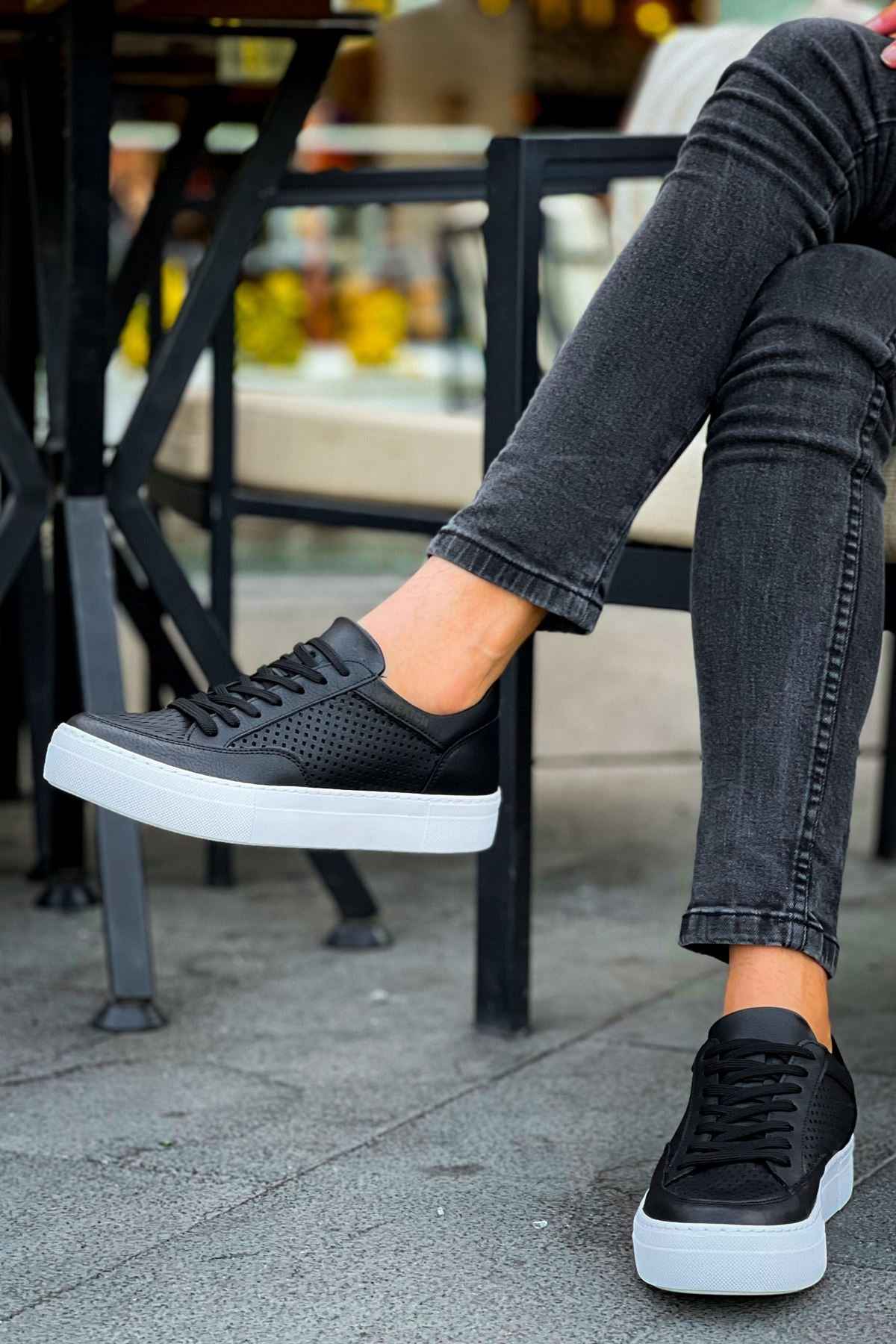 Black low-top sneakers with perforated upper, lace-up front, and white rubber sole